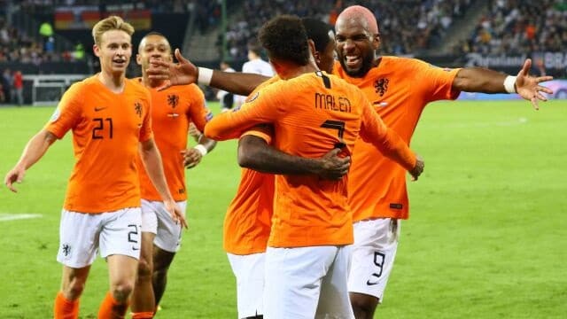Obrazek przedstawia piłkarzy Holandii cieszących się ze zdobytego gola.